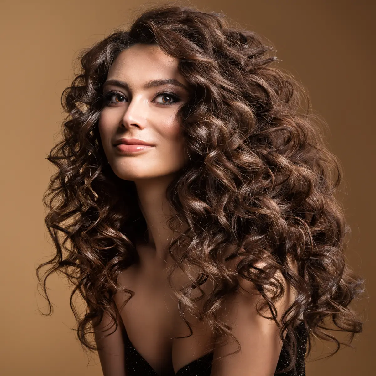 A Gemstone Hair Studio client with long, healthy curls styled with Aveda care in Courtenay